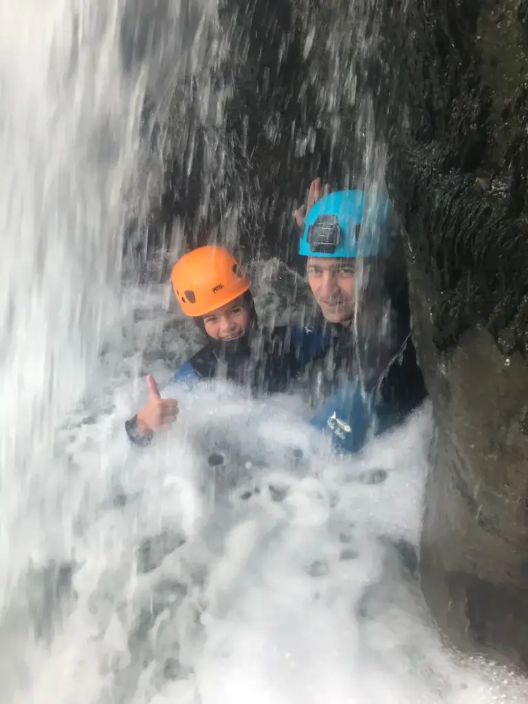 2 personnes derrière une cascade des gorges de Malvaux - Jura