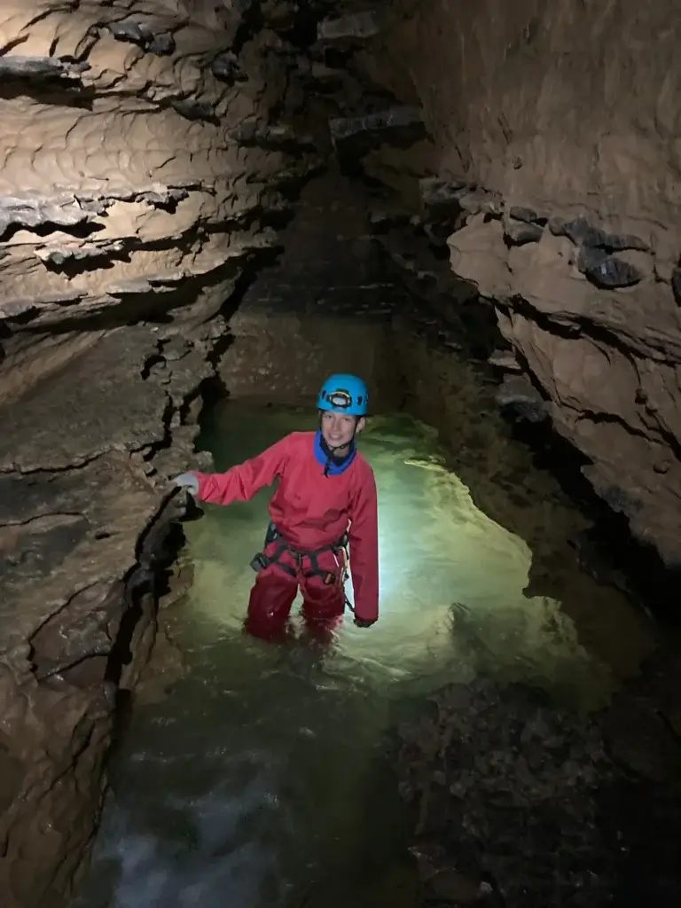 un spéléologue marche dans un bassin d'eau