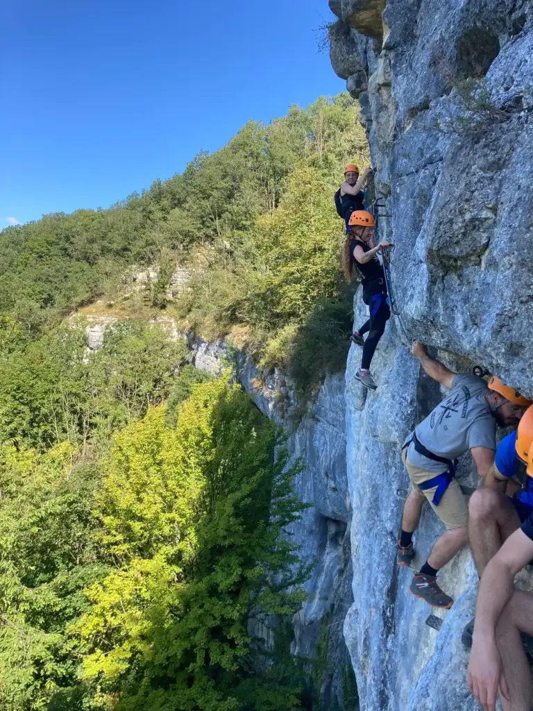 un groupe dans une traversée aérienne de la via-ferrata des baumes du Verneau dans le Doubs