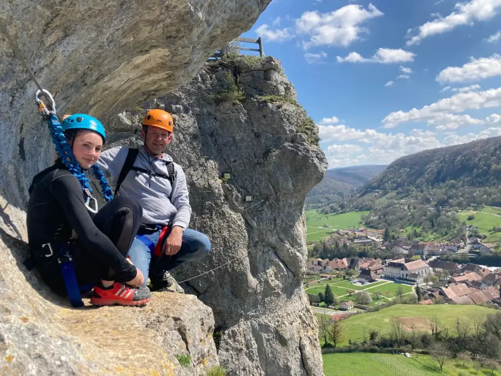 des pratiquants contemplent Ornans dans la via-ferrata de la Roche du Mont - Doubs